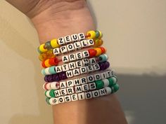 a woman's arm with several bracelets made out of letters and beads on it