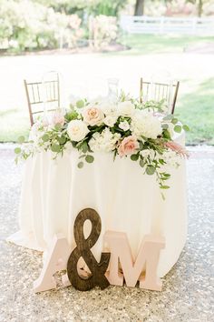 an image of a table with flowers on it and the word mr and mrs spelled out