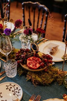 the table is set with plates, silverware, and flowers in glass vases