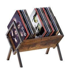 a wooden rack with cd's on it and pictures in the bottom shelf for storage