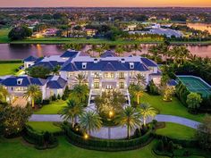 an aerial view of a mansion with tennis courts and palm trees in the foreground