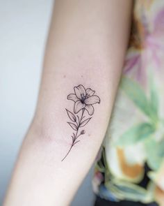 a woman's arm with a flower tattoo on the left side of her arm