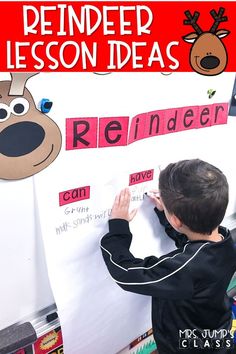 a young boy writing on a bulletin board with reindeer and reindeer head cutouts in the background