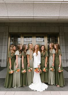 a group of women standing next to each other in front of a door with flowers