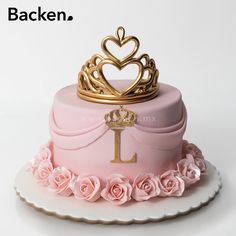 a pink cake with a gold crown on top and roses around the edges that says backen