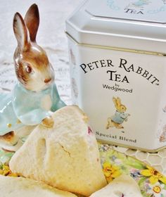 a rabbit figurine sitting on top of a plate next to a box of peter rabbit tea