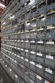 the shelves are full of many different types of screws and nuts in bins