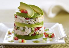 a stack of food that includes avocado and chicken