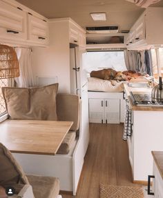 the interior of a small camper with wood flooring and white cabinets is shown