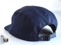 "A navy blue five panel strapback hat, made of medium-weight cotton, with a medium length brim which is unique on the caps market. Out in the woods or in the city, pedal like a madafaca while proudly wearing it. Ride fast through traffic, exercise your body and calm your mind ~ it's also what we believe in. The brim on this model is shorter than most 5 panel hats on the market. In our shop it's considered a medium sized brim (a little bit longer than the kepi brim and a little bit shorter than t Navy Baseball Cap With Short Brim For Outdoor, 5-panel Baseball Cap For Streetwear, Blue 5-panel Dad Hat For Outdoor, Blue Six-panel Sports Hat, Navy 5-panel Hats For Streetwear, Navy Six-panel Snapback Hat For Outdoor, Navy 5-panel Sports Hat, Navy Adjustable 5-panel Baseball Cap, Navy Cotton 5-panel Baseball Cap