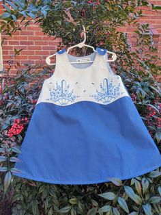 This sweet size 4T dress/jumper  is made of a dark blue percale from a repurposed sheet. The bodice is adorned with beautiful hand embroidered baskets of flowers in coordinating blues, from a repurposed vintage pillowcase! It snaps at shoulders for easy dressing, and is fully lined with a soft light blue percale. Perfect for Easter, birthdays, or everyday wear! All of my products are handmade, prewashed, one of a kind, and made from thrifted, repurposed fabrics, laces, buttons and trims! Cute Blue Dresses With Floral Applique, Cute Blue Dress With Floral Applique, Blue Cotton Dress With Floral Applique, Upcycled Blue Cotton Dress, Handmade Blue Dresses For Spring, Baskets Of Flowers, Girl Frock, 4t Dress