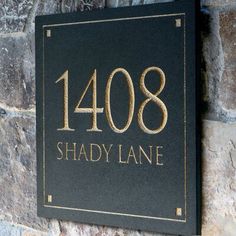 a black and gold plaque with the name shady lane written in gold lettering on it