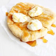 pancakes with butter and syrup on top sitting on a white paper towel covered in wax paper