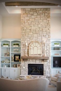 a living room filled with furniture and a fire place in front of a stone fireplace