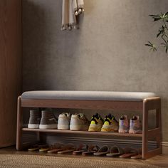 a wooden shoe rack filled with pairs of shoes next to a wall mounted coat rack