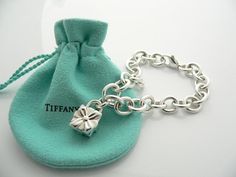 Offered for sale is a wonderful and super cute Tiffany and Co. Sterling Silver Signature Gift Box Charm bracelet.   The piece is made from substantial and bright Tiffany silver, and yet retains a very feminine feel to it.  Attached to its very substantial and bright Tiffany Silver charm bracelet is a super Cool Signature Gift Box Padlock charm.  The Gift Box padlock charm opens and closes, and thus can be used as a charm on a necklace or as part of another charm bracelet! Super versatile piece! Designer Rectangular Bracelets As Gift, Luxury Rectangular Bracelet As Gift, Luxury Rectangular Bracelet Gift, Elegant Rectangular Jewelry For Birthday Gift, Elegant Engraved Bracelet For Birthday, Elegant Engraved Bracelet For Birthday Gift, Designer Silver Jewelry With Original Box, Designer Silver Jewelry In Original Box, Luxury Silver Jewelry With Original Box