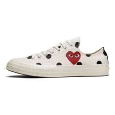 Introducing the Converse Comme des Garcons x Chuck Taylor All Star 70 Low Polka Dot sneaker. This unique sneaker celebrates the iconic 70s silhouette in a collaboration with Japanese label CDG PLAY. The low-top design features a cream-based upper adorned with an allover black polka dot design. The signature CDG PLAY heart-and-eyes motif, originally designed by New York artist Filip Pagowski, makes a few appearances throughout the shoe. Tonal laces, silver hardware, and an Off-White rubber toe cap complete the design of this must-have sneaker. 70s Silhouette, Converse X Comme Des Garcons, Converse Comme Des Garcons, Play Heart, Cdg Play, Unique Sneakers, White High Tops, Comme Des Garcons Play, Women's Converse