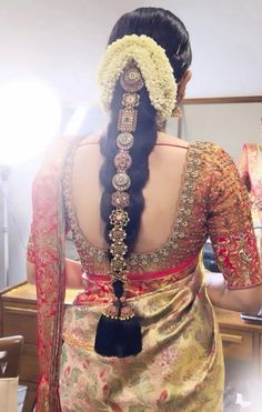 the back of a woman's head with braids and flowers in her hair