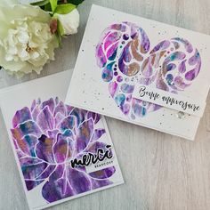 two cards with watercolor designs on them, one is purple and the other is white