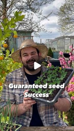 a man holding a tray with plants in it and the words, guaranted seed success