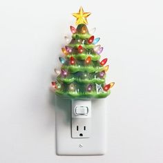 a green christmas tree light switch cover on a white wall