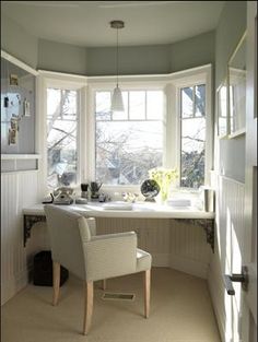 a chair sitting in front of a window next to a desk