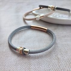 This stunning leather bracelet is made from super soft nappa leather, with 6 colour options - Powder pink, Dove Grey, Dark Grey, Navy, or Black. A lovely gift for women on Valentines Day, Mother's Day, or 30th, 40th, 50th birthday Your bracelet comes with a sterling silver barrel, choose rings to customise your bracelet! Choose from the dropdown menu. (If you can't see an option you like in the menu please message me) Choose from: Sterling Silver (S) or Oxidised Silver (OS): £5 each 9ct Rose  (R Leather Friendship Bracelet, Summer Jewellery, Personalized Leather Bracelet, 3rd Anniversary, Gold And Silver Rings, 40th Birthday Gifts, 30 Gifts, Dove Grey, Powder Pink