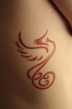 a woman's stomach with a tattoo design on the side of her body,