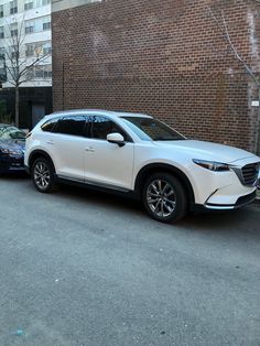 two cars parked next to each other in front of a brick building