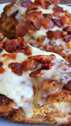 two pieces of pizza covered in bacon on a plate