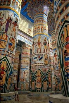 the interior of an egyptian style building with painted columns and murals on it's walls