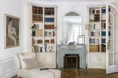 a living room filled with furniture and bookshelves next to a fire place in front of a fireplace