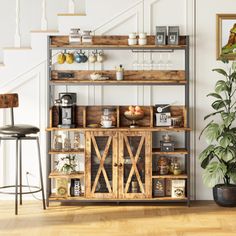 a living room filled with furniture next to a stair case and potted plant on top of a hard wood floor