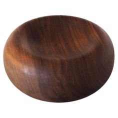 a wooden bowl sitting on top of a white surface