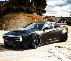 a black sports car parked in front of a bridge