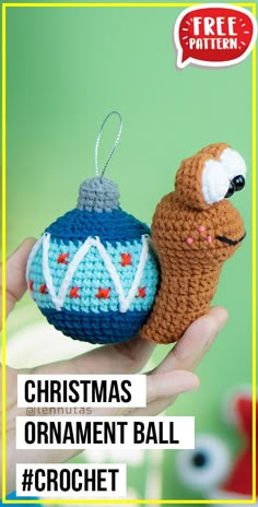 a crochet christmas ornament ball with a snail on it's back