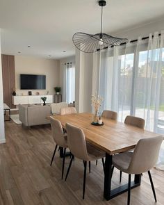 a dining room table with chairs and a television on the wall