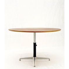 a round wooden table sitting on top of a metal base