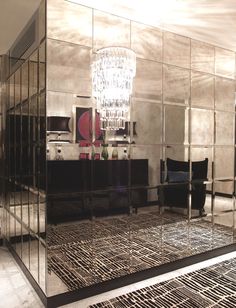 a large mirrored room with a chandelier hanging from it's side wall