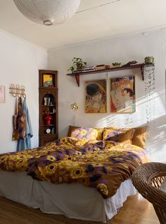 a bed sitting in a bedroom next to a wooden shelf filled with books and plants