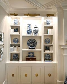 the shelves are filled with blue and white plates, vases and other decorative items