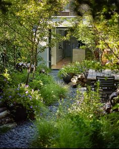 an outdoor dining area surrounded by trees and plants