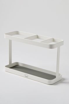 a white shelf with two trays sitting on it's sides in front of a gray background