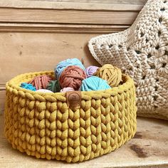 a yellow basket filled with balls of yarn