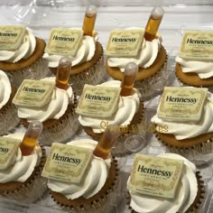 cupcakes with white frosting and brown icing in a plastic container on top of each other