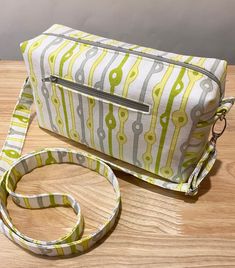 a green and white bag sitting on top of a wooden table next to a lanyard