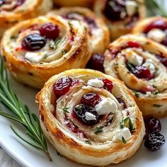 cranberry rolls on a white plate topped with cream cheese