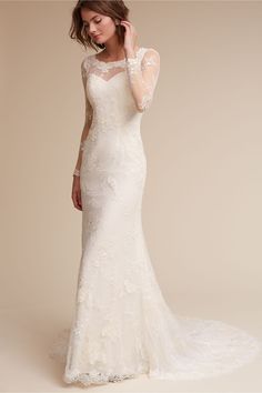 a woman in a white wedding dress posing for the camera with her hand on her head