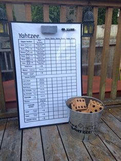 a bucket filled with dices sitting on top of a wooden deck next to a sign