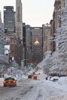 cars driving down a snow covered city street